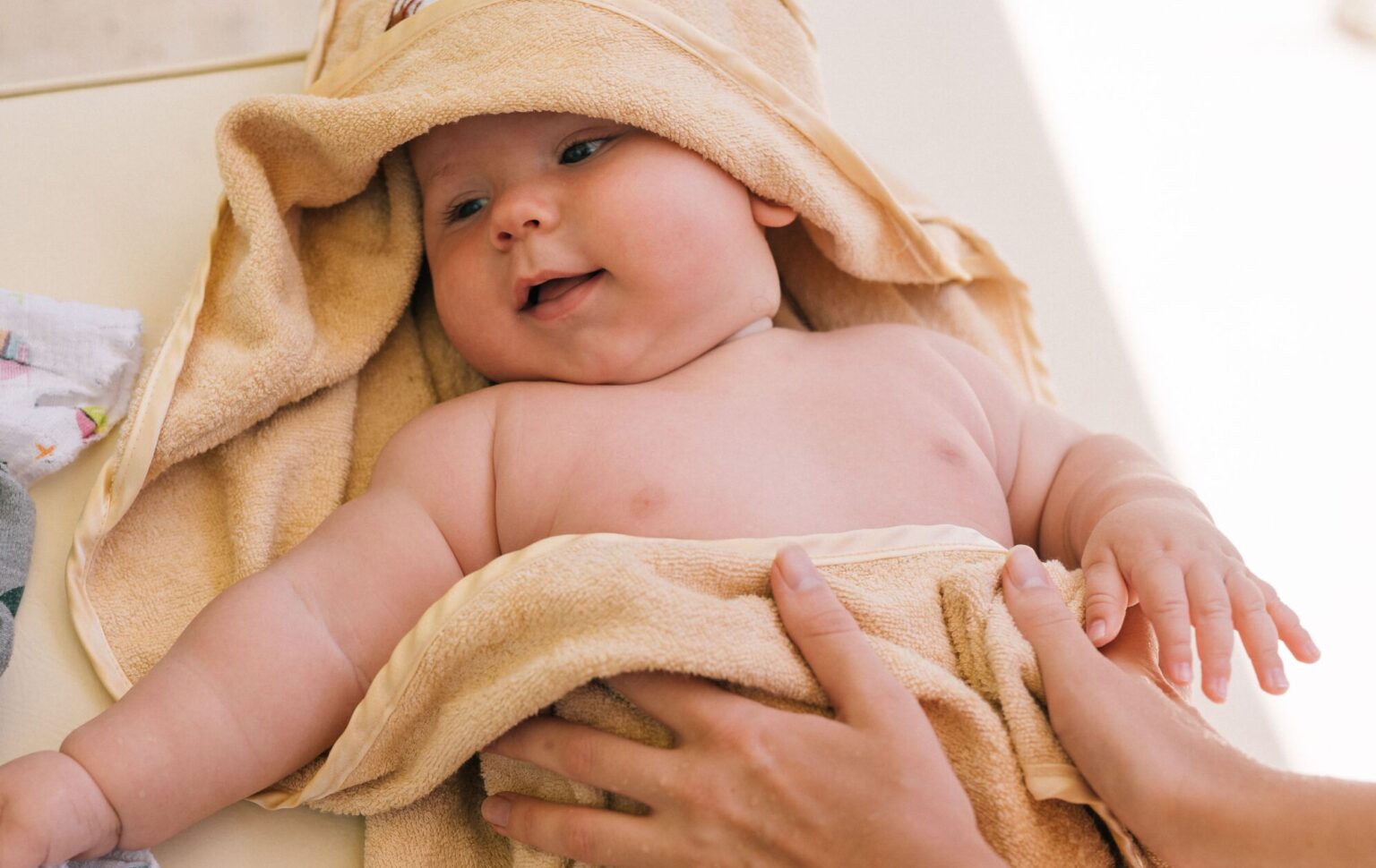 Newborn Towels Cute newborn baby wrapped in a soft towel, smiling and feeling cozy indoors.