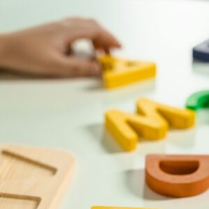 Colorful wooden alphabet letters scattered on a white surface for educational activities.