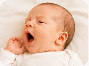 Parent gently soothing a sleeping baby during a Baby Care bedtime routine