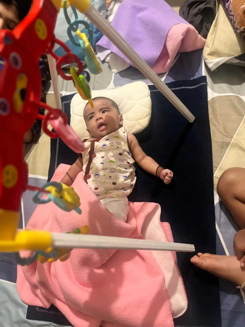 Young baby looking at a colourful hanging toy during playtime