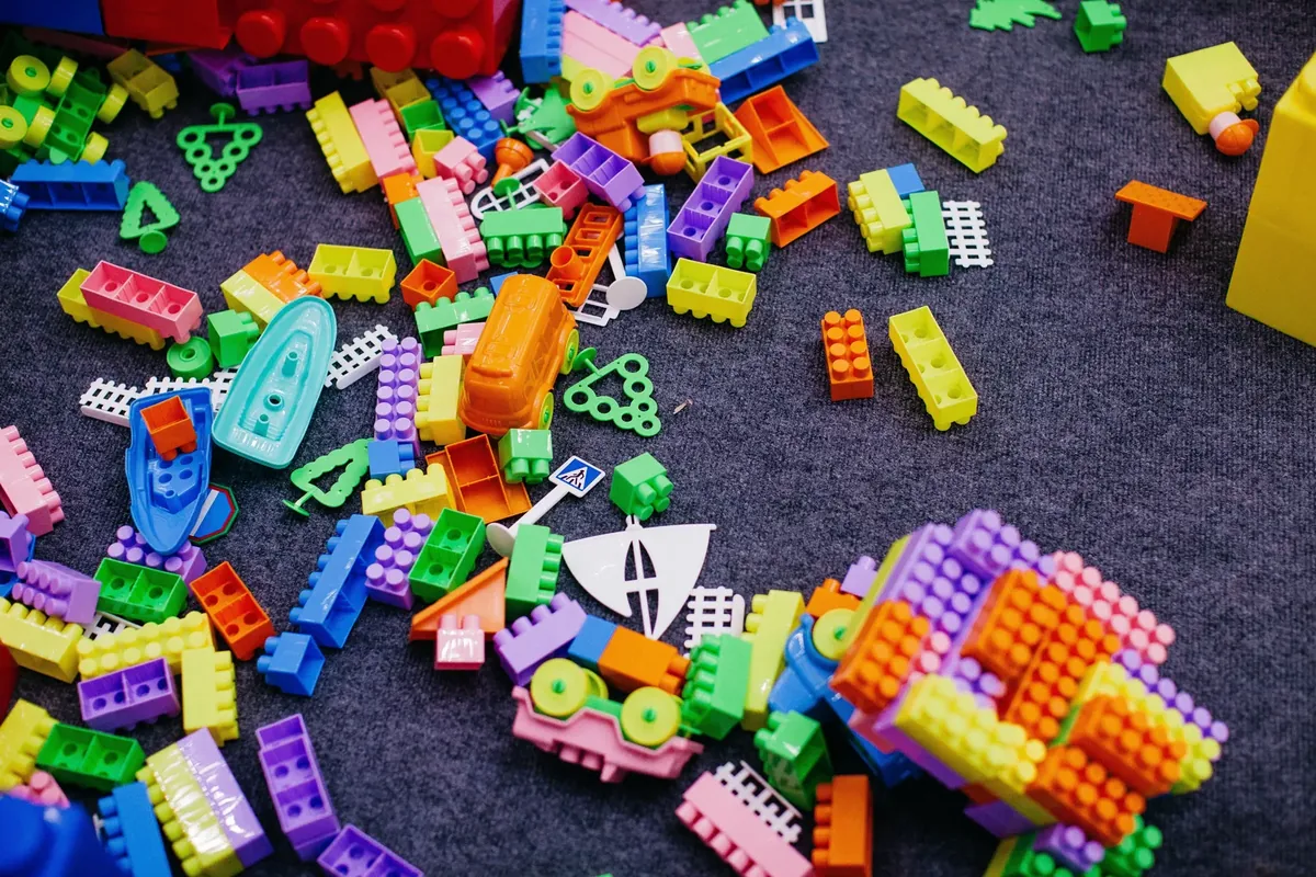 Colorful building blocks scattered across the floor, representing open-ended toys that support real play
